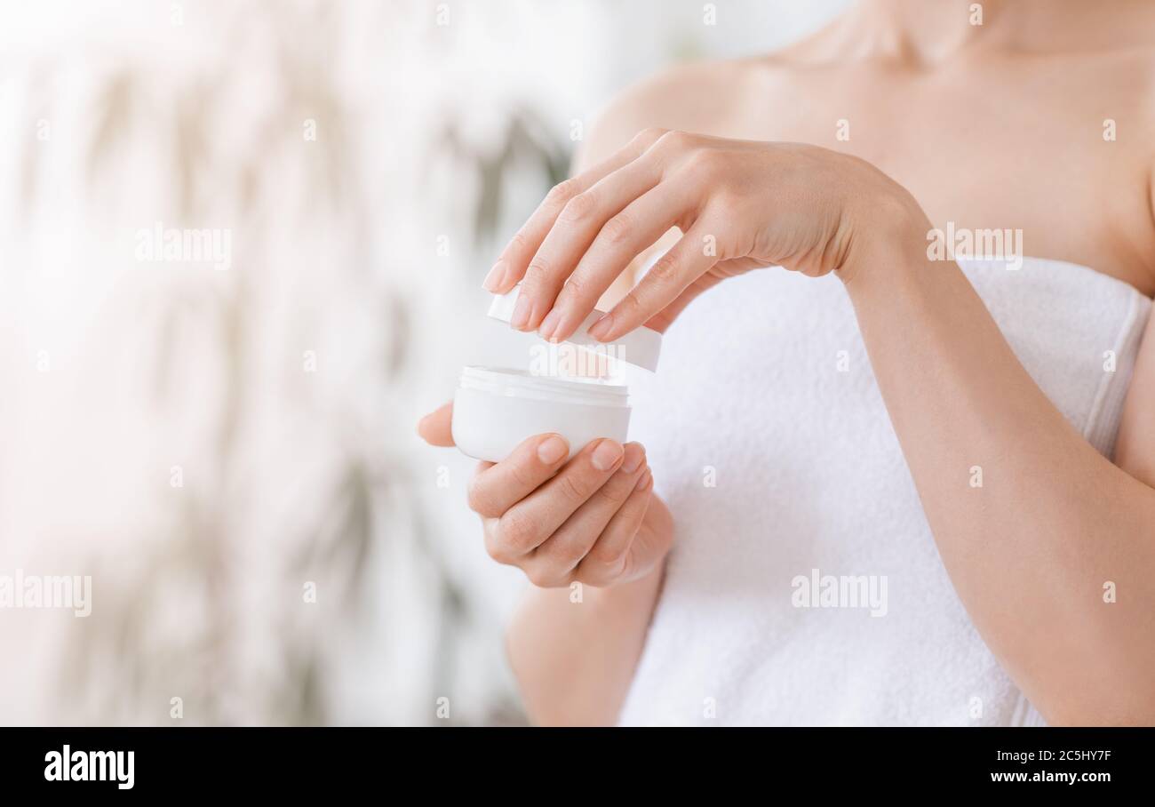 Close up of woman opening jar with cream Stock Photo