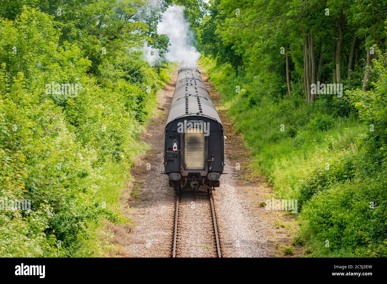 Railway bridge view of a famous, British steam seen pulling a number of passenger
