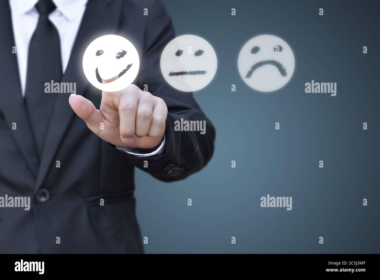 Businessman pressing smiley face icon on virtual screen. Concept of satisfaction evaluation and feedback. Stock Photo