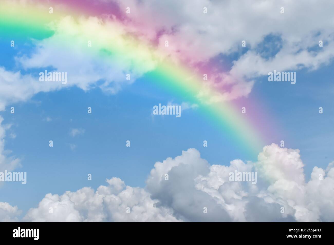 Rainbow on blue sky with white cloud background Stock Photo - Alamy