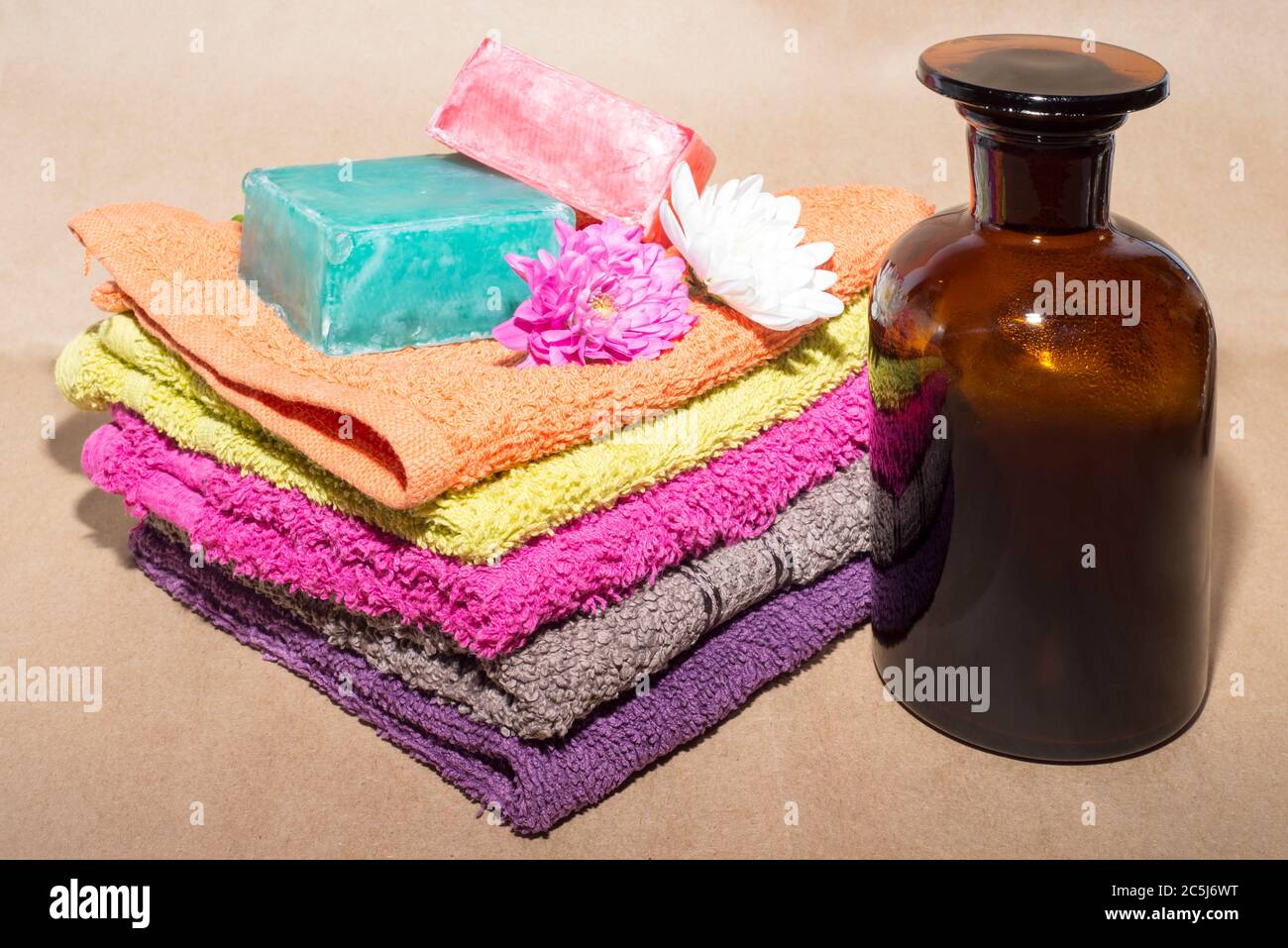 soap bar on top of facecloths off various shades with flowers and bottle Stock Photo