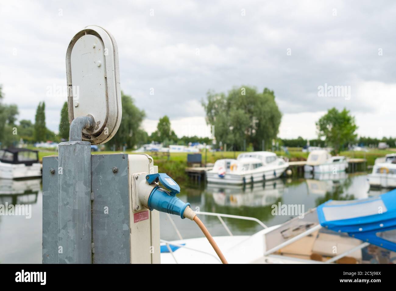Electrical, waterproof power outlet seen connected to a fed cable at a