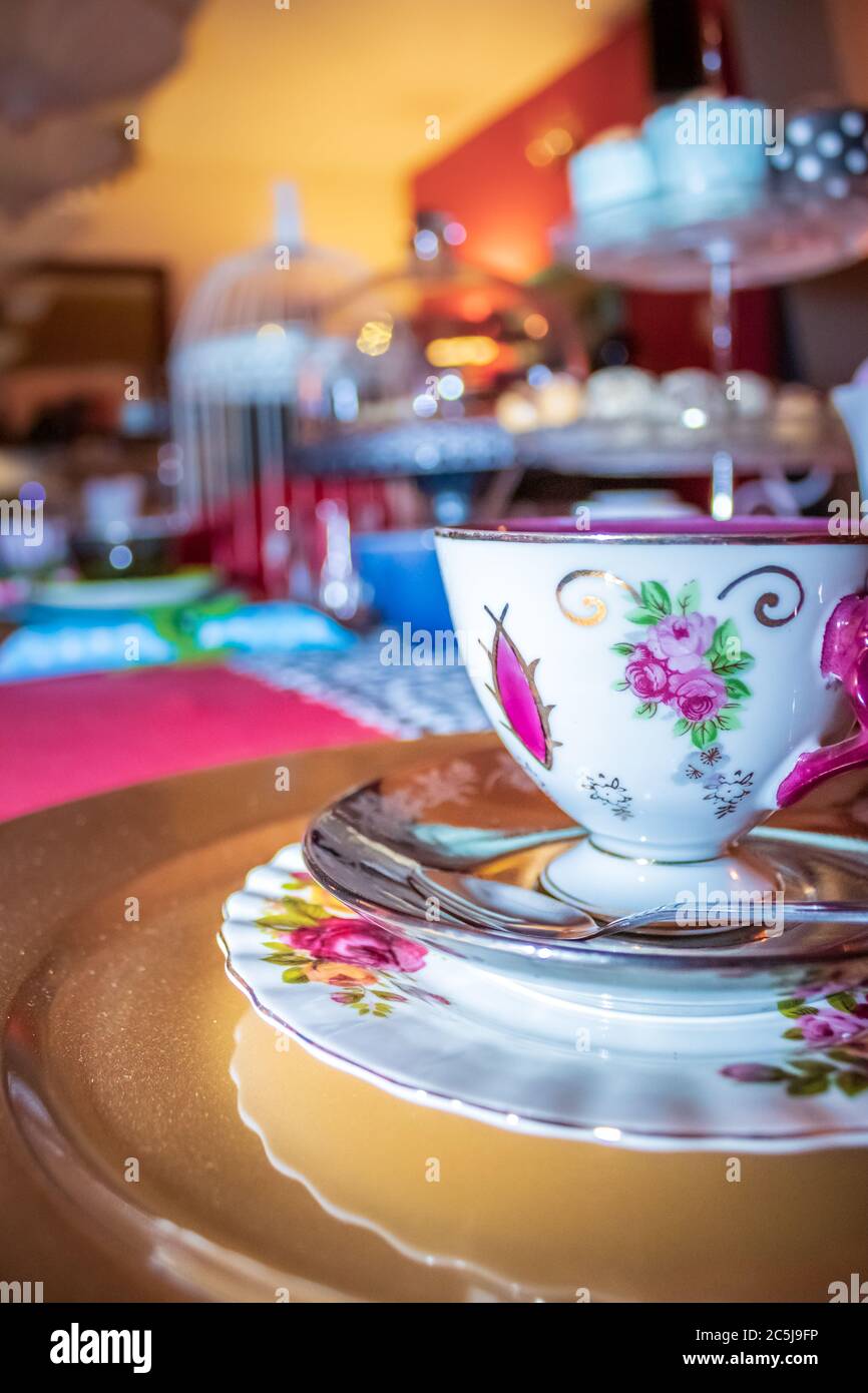Colorful Tea party with table laid out fancy tea cups and saucers, with