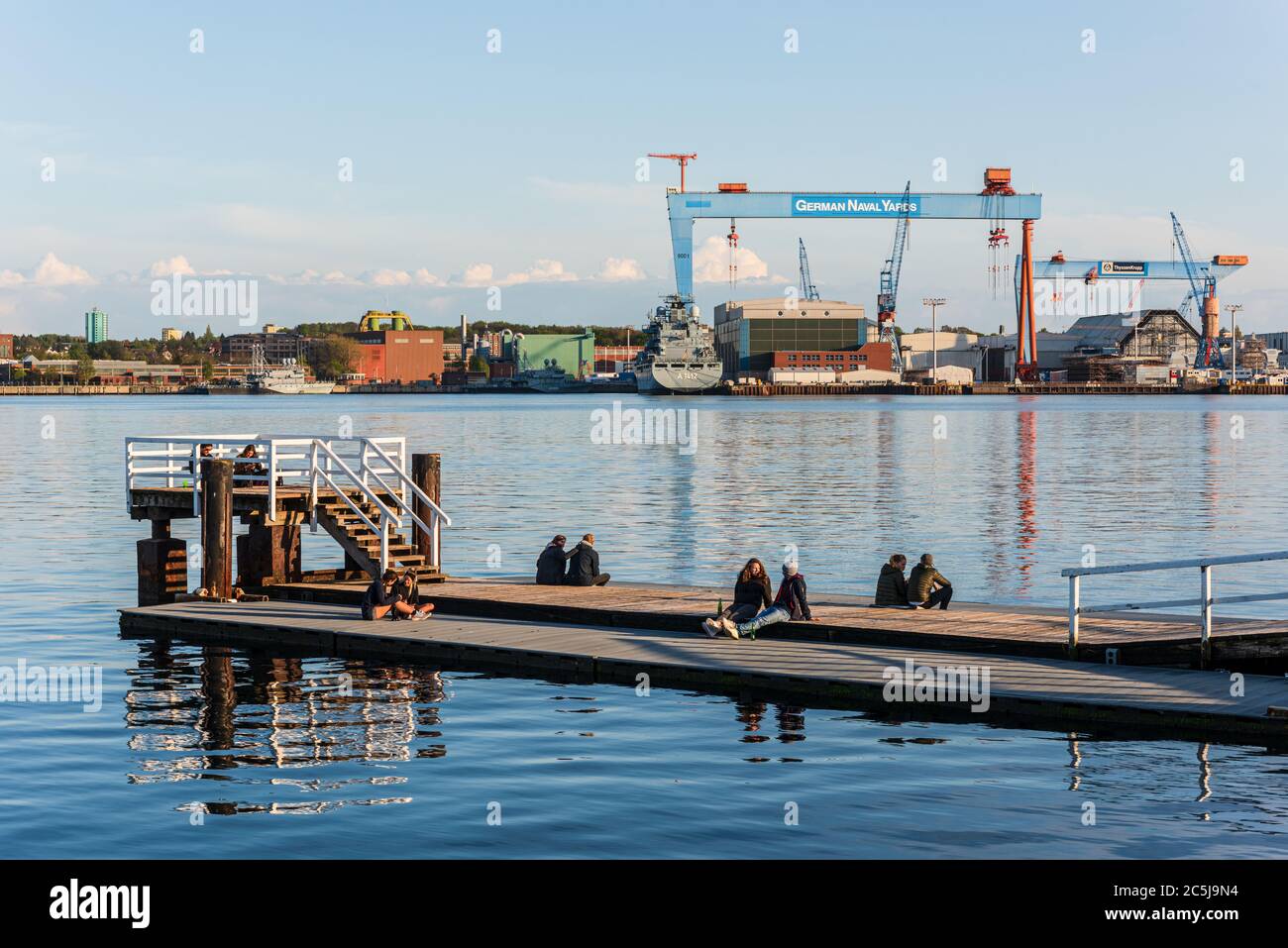 Abendstimmung an der Kiellinie, der Uferpromenade an der Kieler Innenförde zu Coronazeiten mit Blick auf die Werften Stock Photo