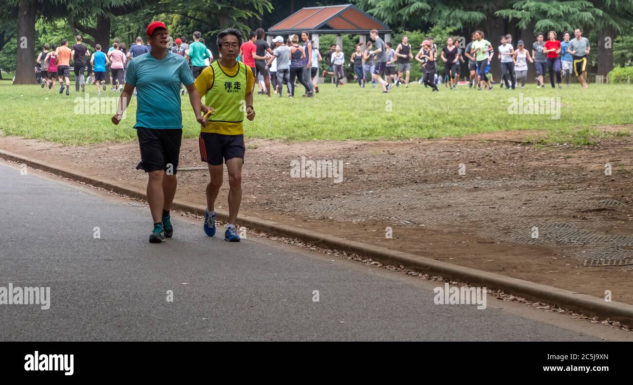 Visually impaired runner with running guide in Yoyogi Park, Tokyo, Japan Stock Photo