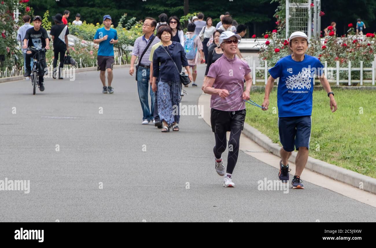 Visually impaired runner with running guide in Yoyogi Park, Tokyo, Japan Stock Photo