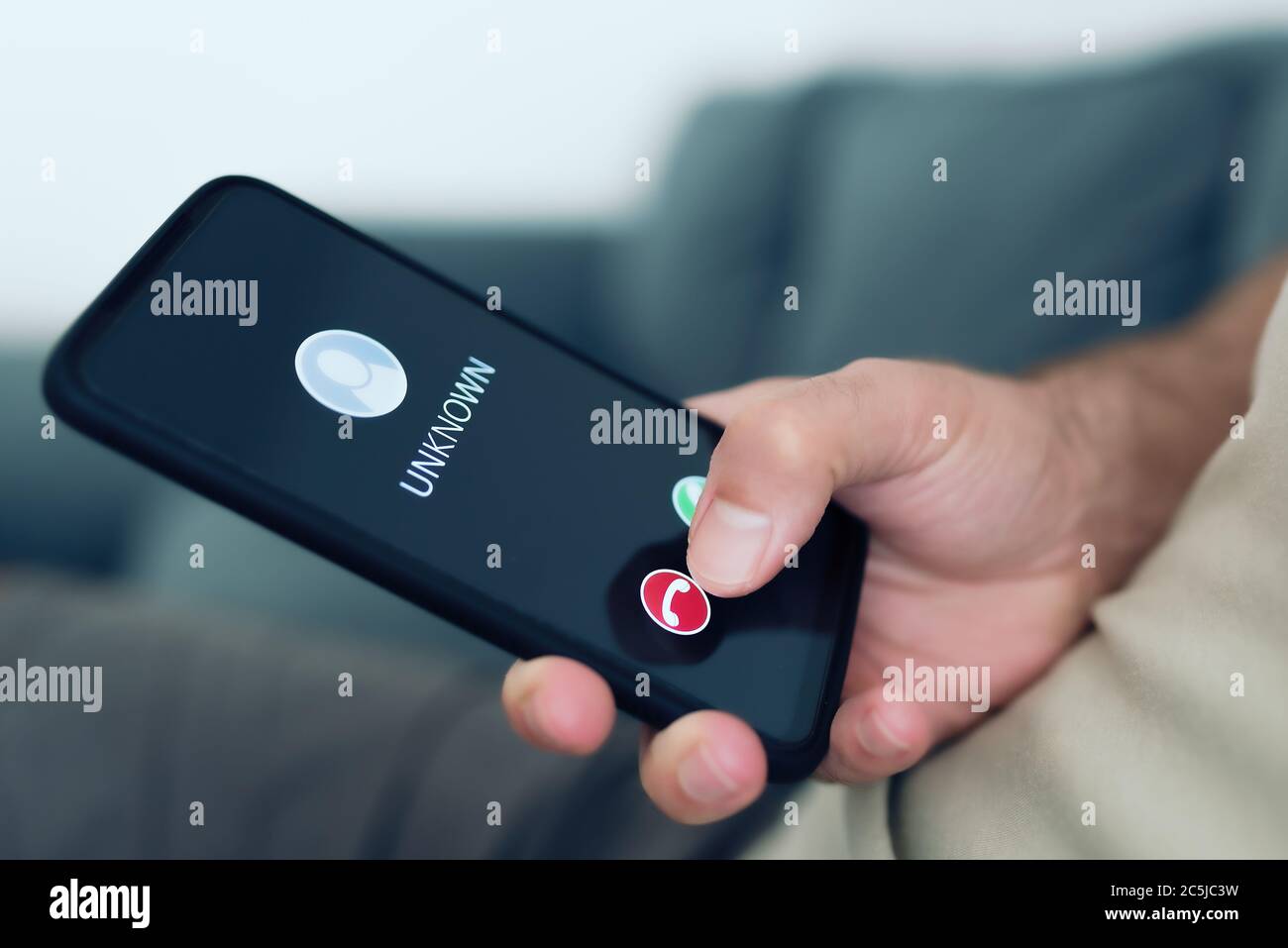 close-up view of person rejecting call from unknown caller or unknown number on smartphone, phone scam and phishing concept Stock Photo
