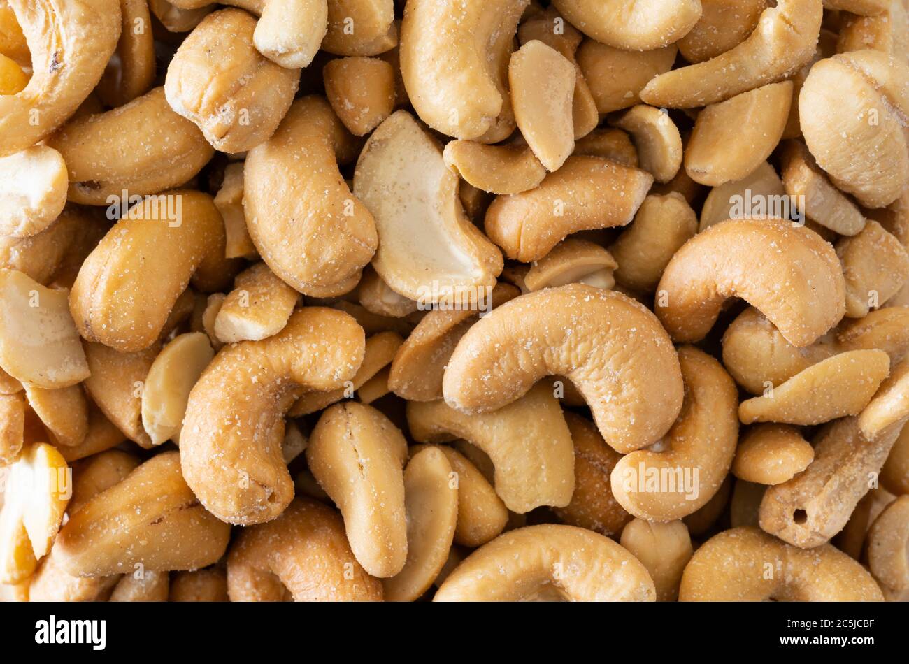 A macro closeup of salted cashew nuts - a popular ingredient for Asian cuisine - filling the picture frame as a background Stock Photo