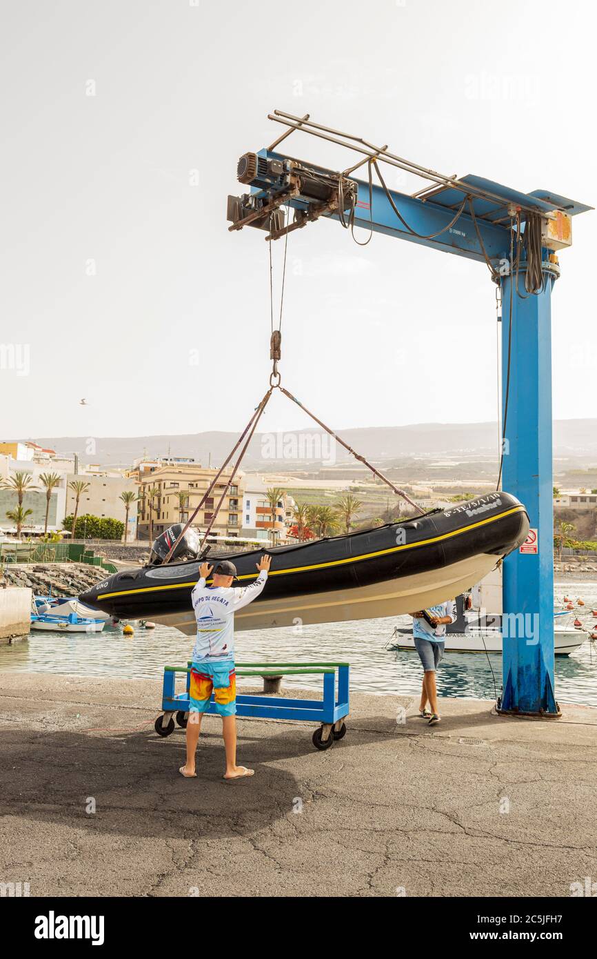 Preparing to launch a RIB, rigid inflatable boat by crane from Playa San Juan, Tenerife, Canary Islands, Spain Stock Photo