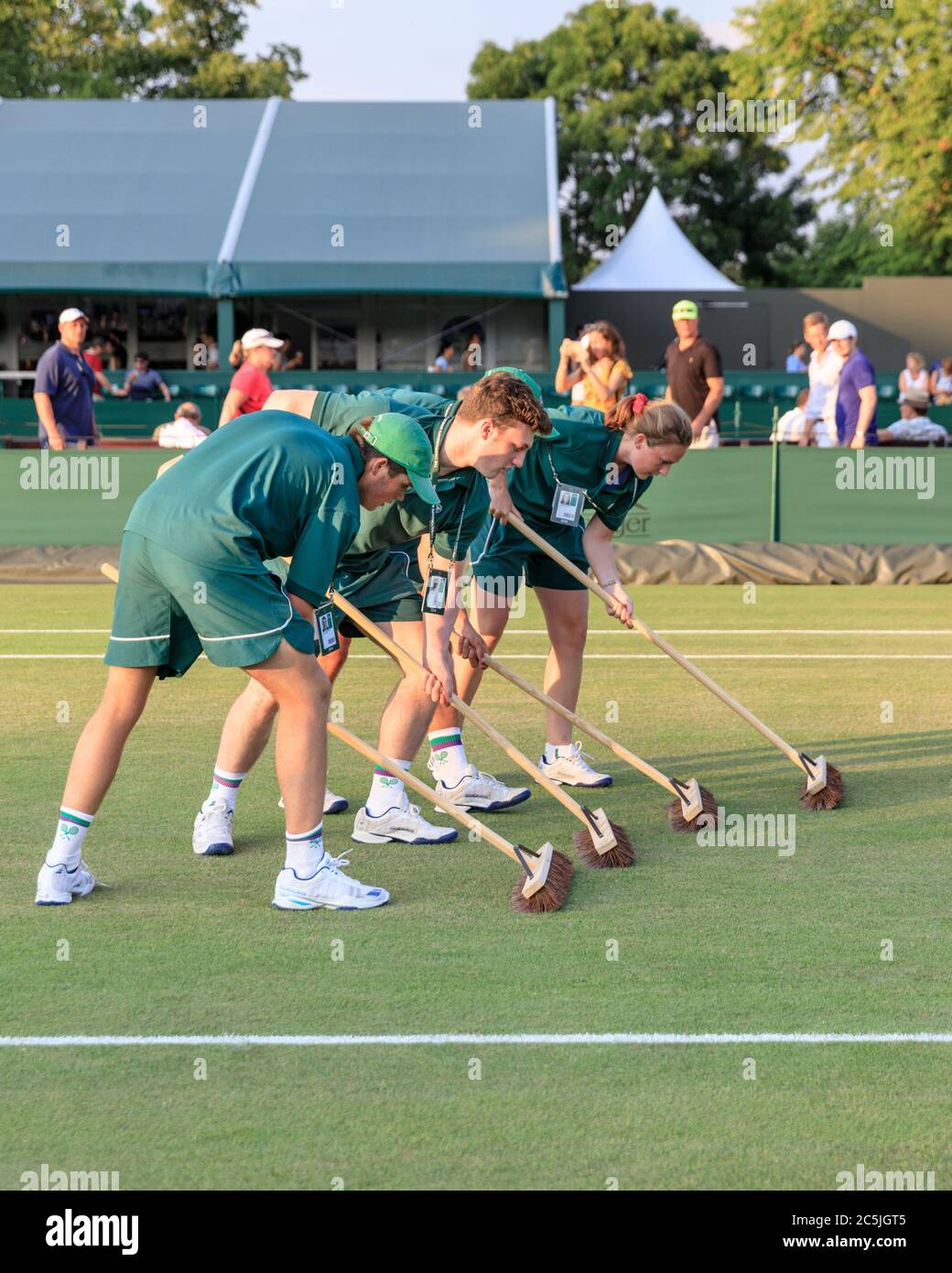 Court maintenance attendants swipe a Wimbledon grass court to preserve the lawn Stock Photo