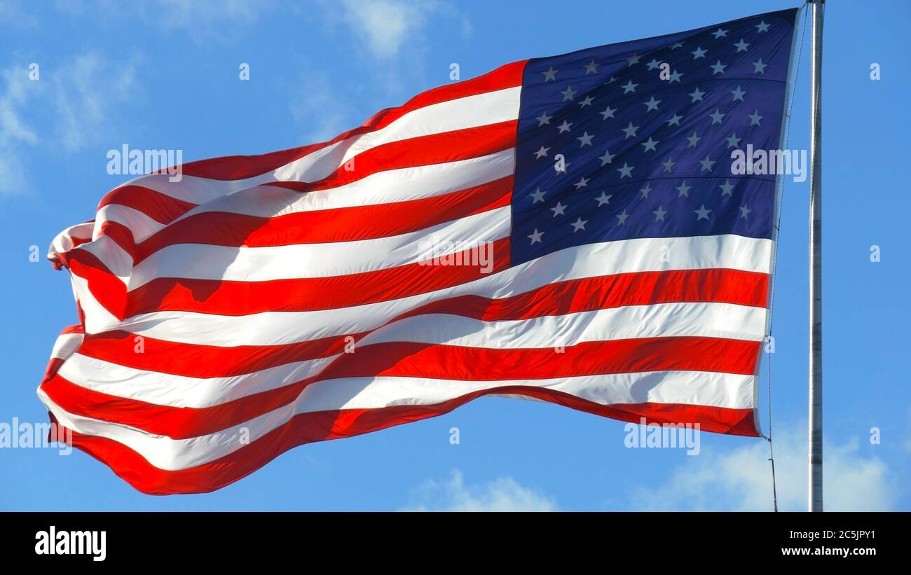 American Flag Waving Under A Blue Sky With Clouds Stock Photo
