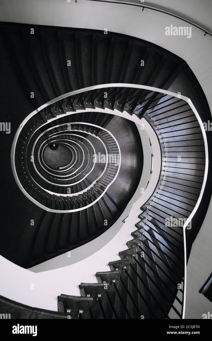 looking deep into long spiral stair case of big building, concept photo ...