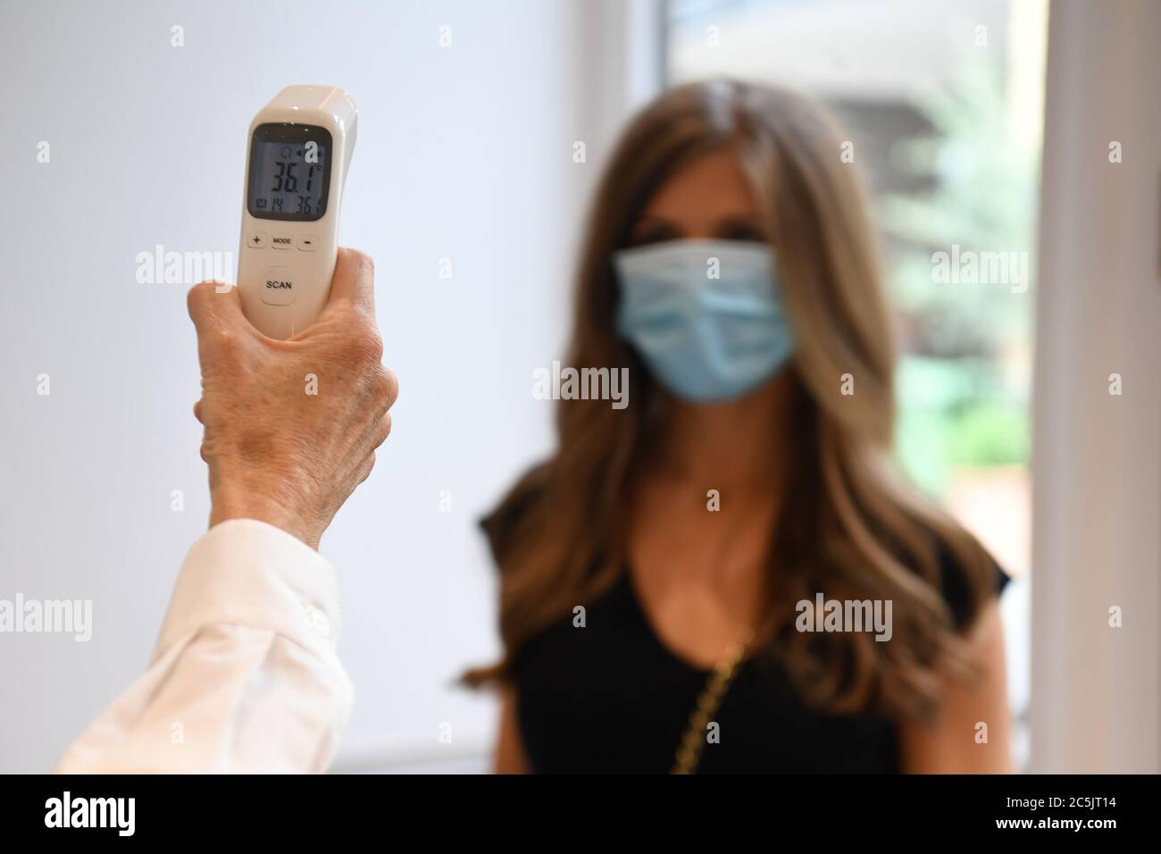Co-founder Belle Cannon checks a mock client's temperature at Salon Sloane in Chelsea, London, as they prepare to reopen to the public on Saturday, when the lifting of further lockdown restrictions in England comes into effect. Stock Photo