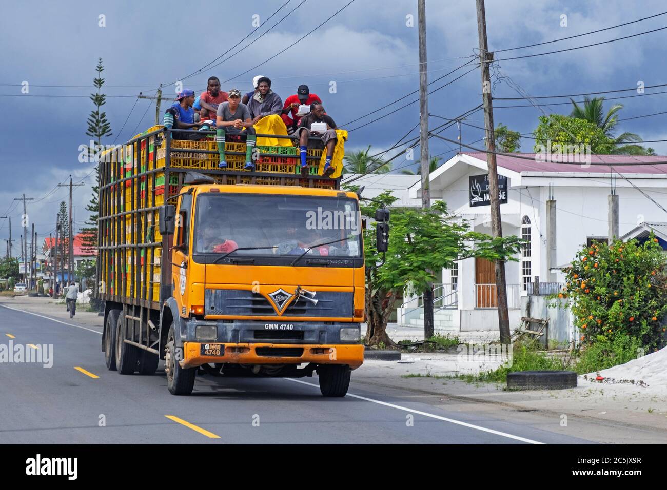 Workers on top of heavily laden truck in the village Soesdyke, Essequibo Islands-West Demerara Region, Guyana, South America Stock Photo