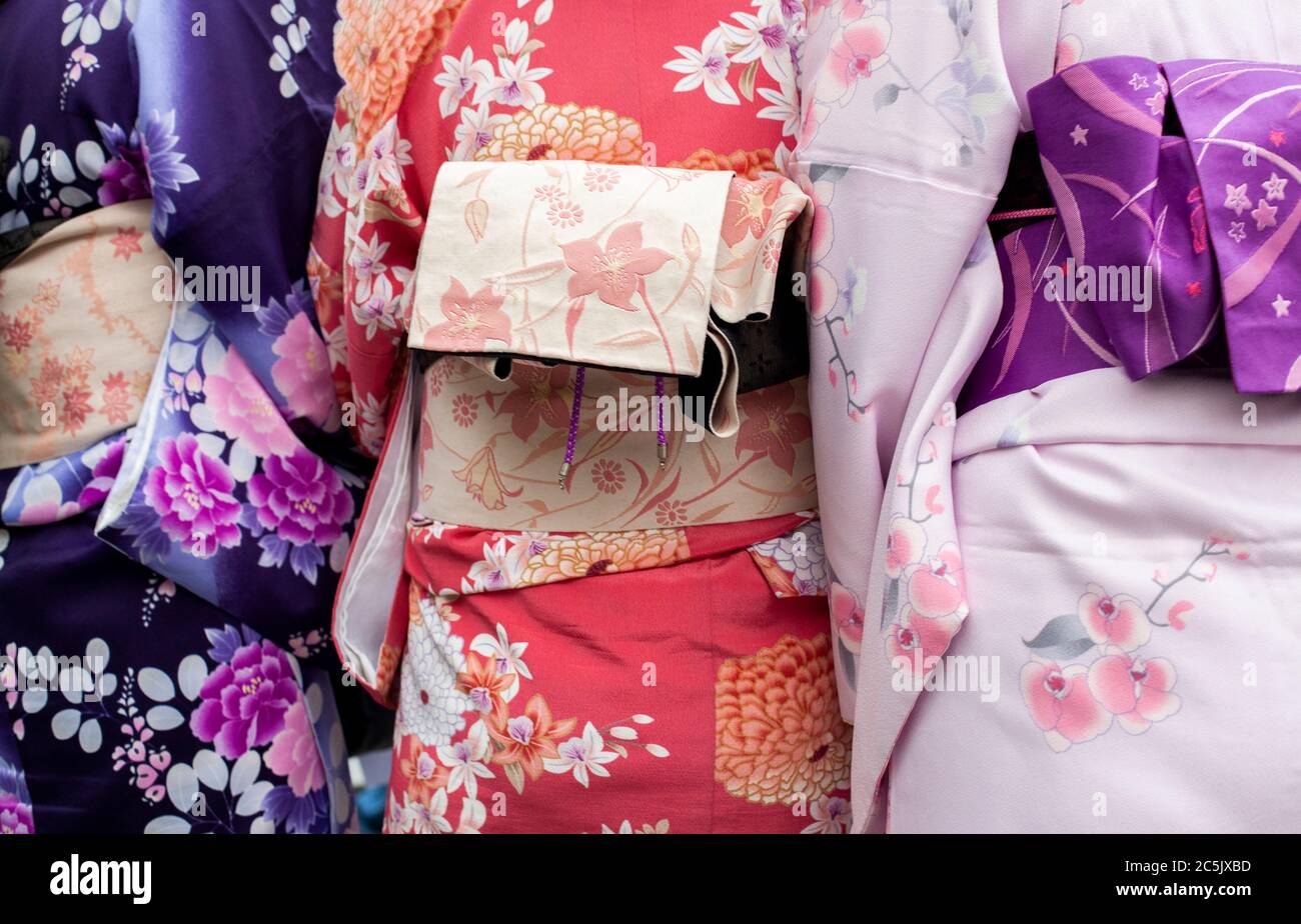 Closeup detail of three women wearing traditional Japanese kimonos in