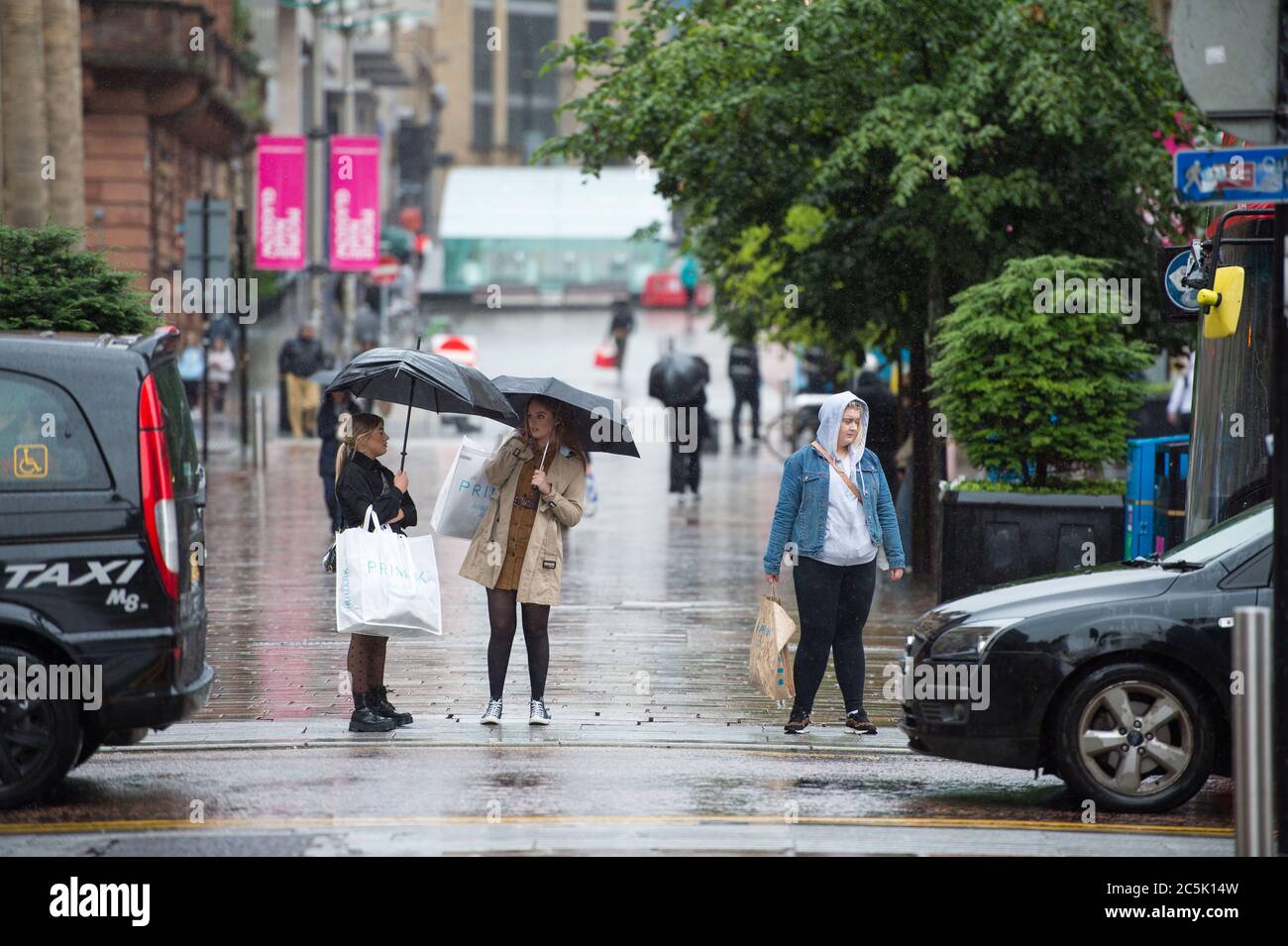 Glasgow, Scotland, UK. 3rd July, 2020. Pictured: Buchanan Street shopping area with shoppers braving the pouring rain using umbrellas and face coverings which will become mandatory on 10th July next week. Credit: Colin Fisher/Alamy Live News Stock Photo