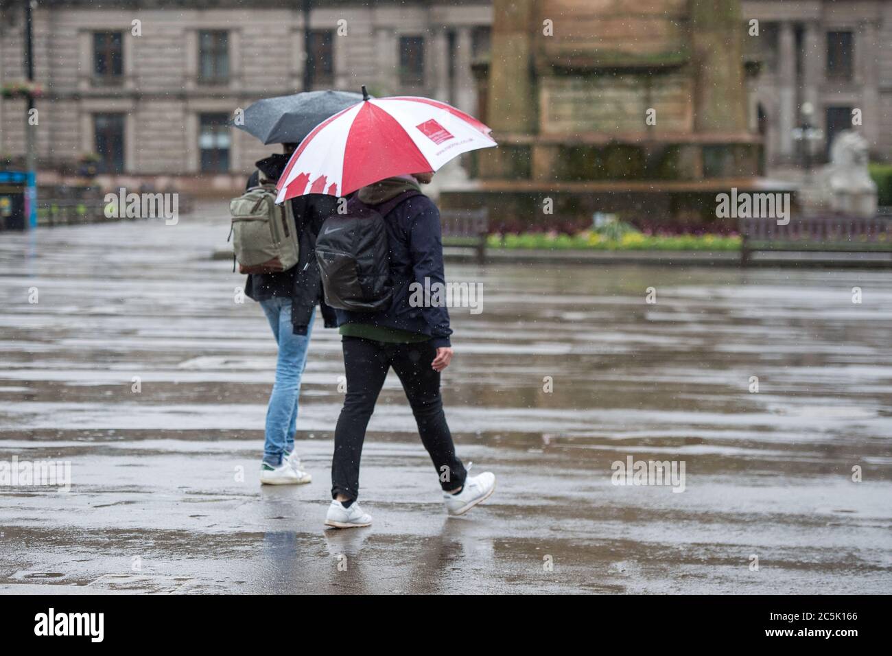 Glasgow, Scotland, UK. 3rd July, 2020. Pictured: A deserted George Square. Buchanan Street shopping area with shoppers braving the pouring rain using umbrellas and face coverings which will become mandatory on 10th July next week. Credit: Colin Fisher/Alamy Live News Stock Photo