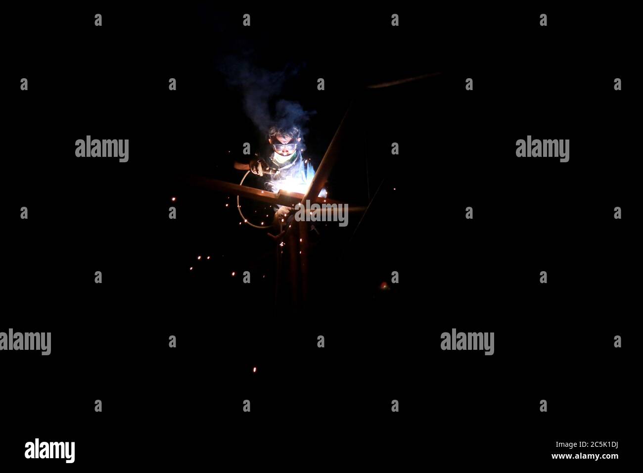 Kathmandu, Nepal. 3rd July, 2020. A worker welds an iron rods together