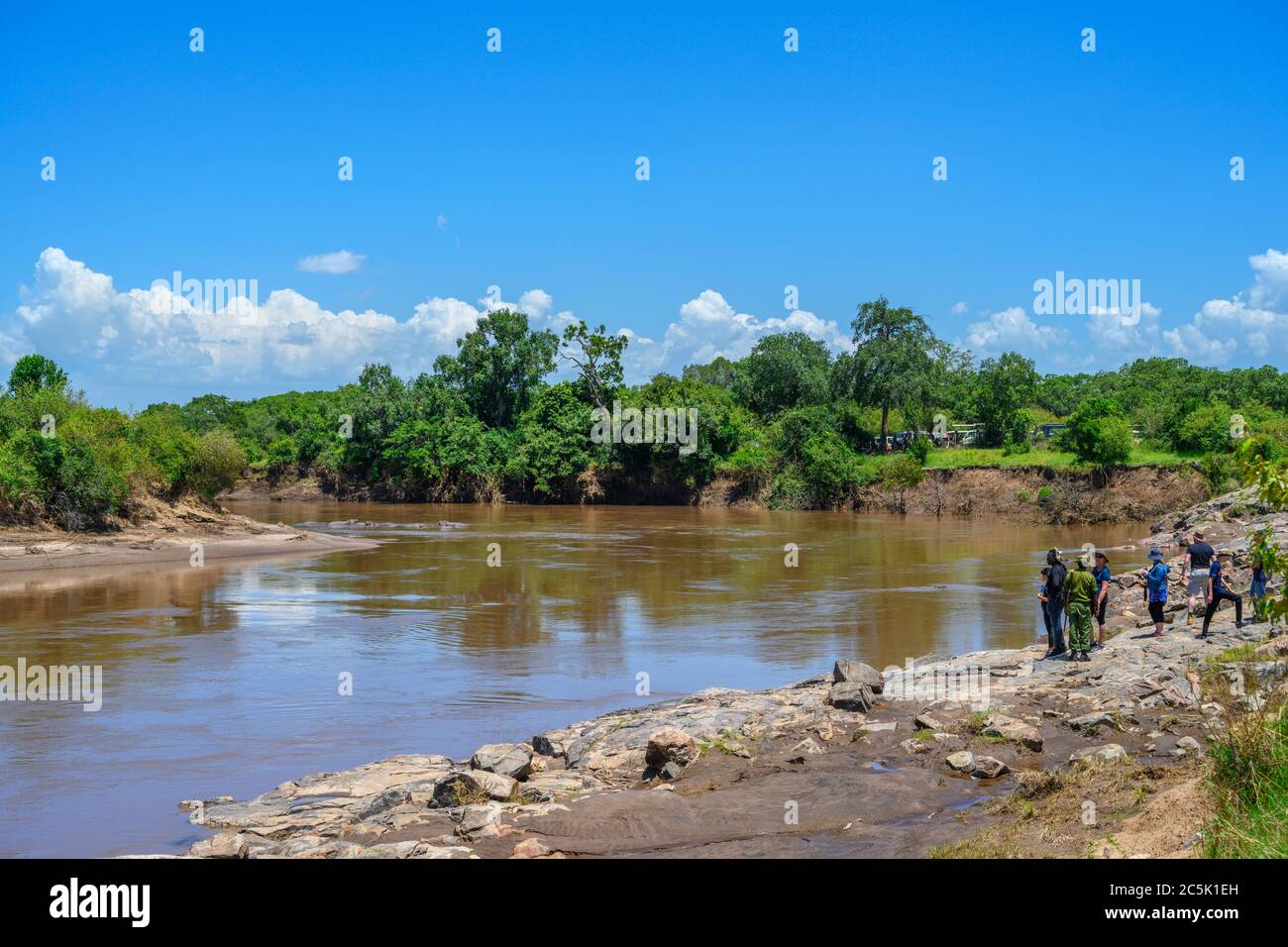 Tourists and park rangers looking at hippos in the Mara River, Mara Triangle, Masai Mara National Reserve, Kenya, East Africa Stock Photo