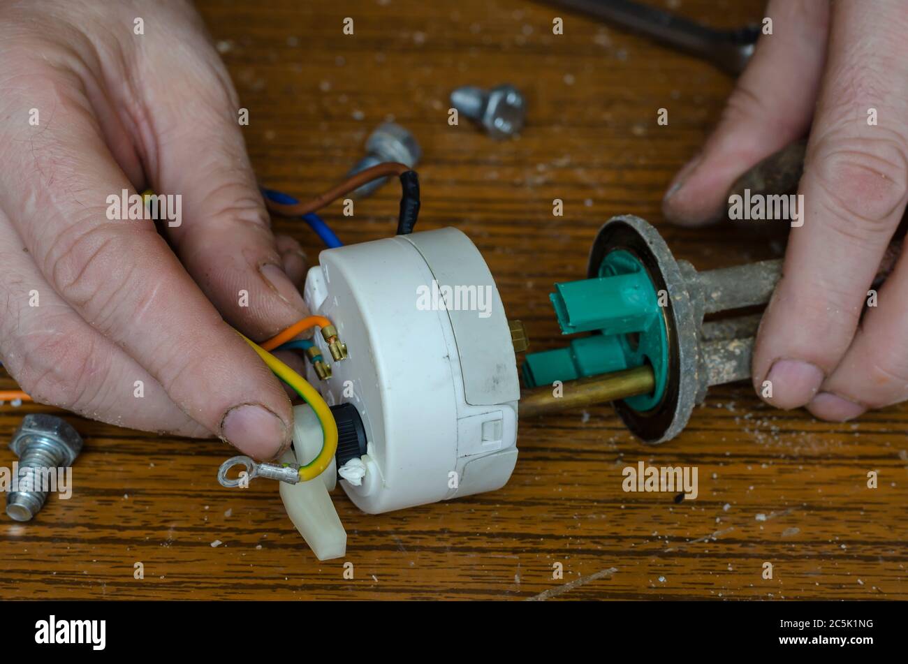 Repair of a water heater part 1 2. Man's hands hold the heating element