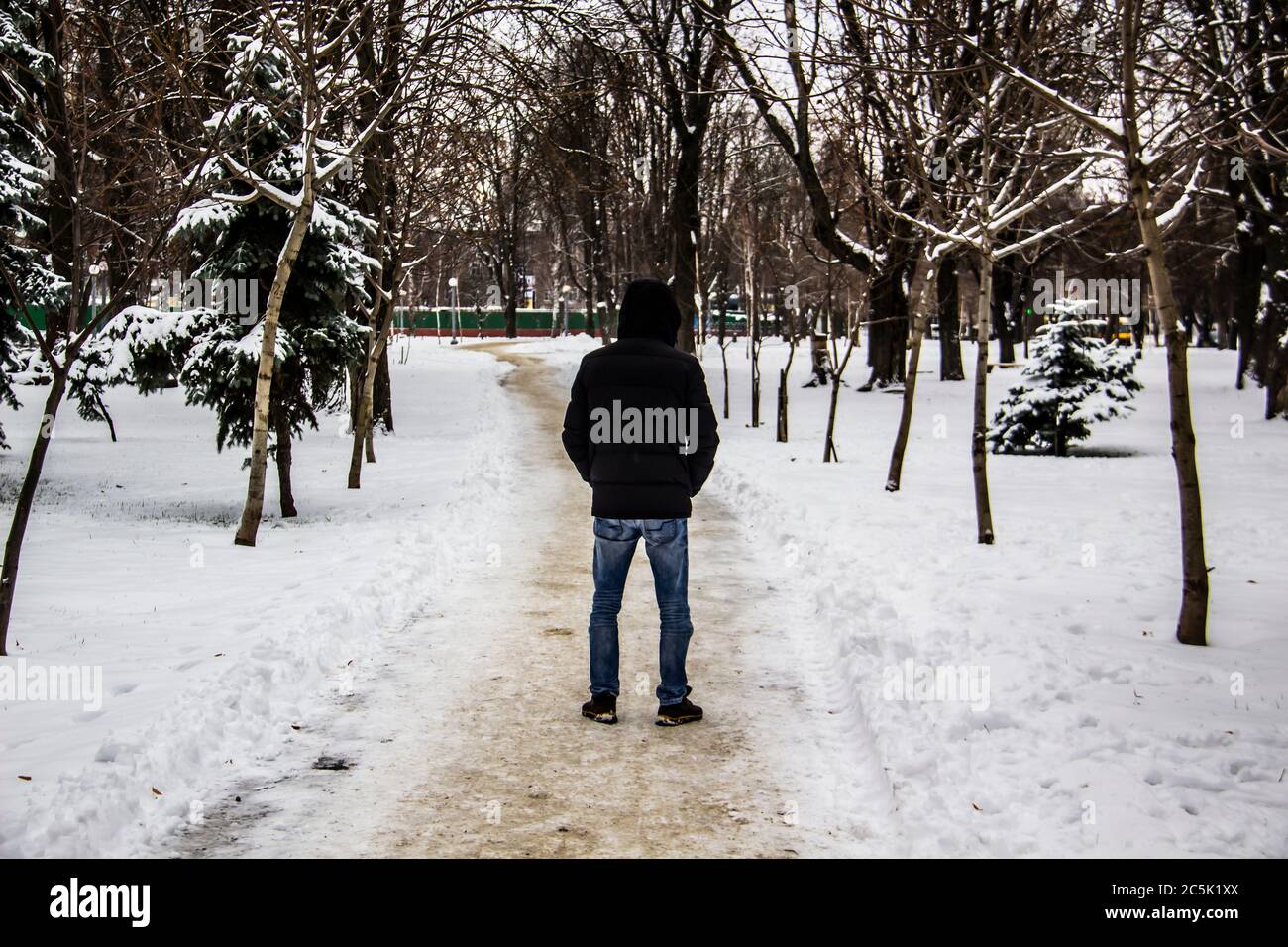 A guy in a black jacket is walking 