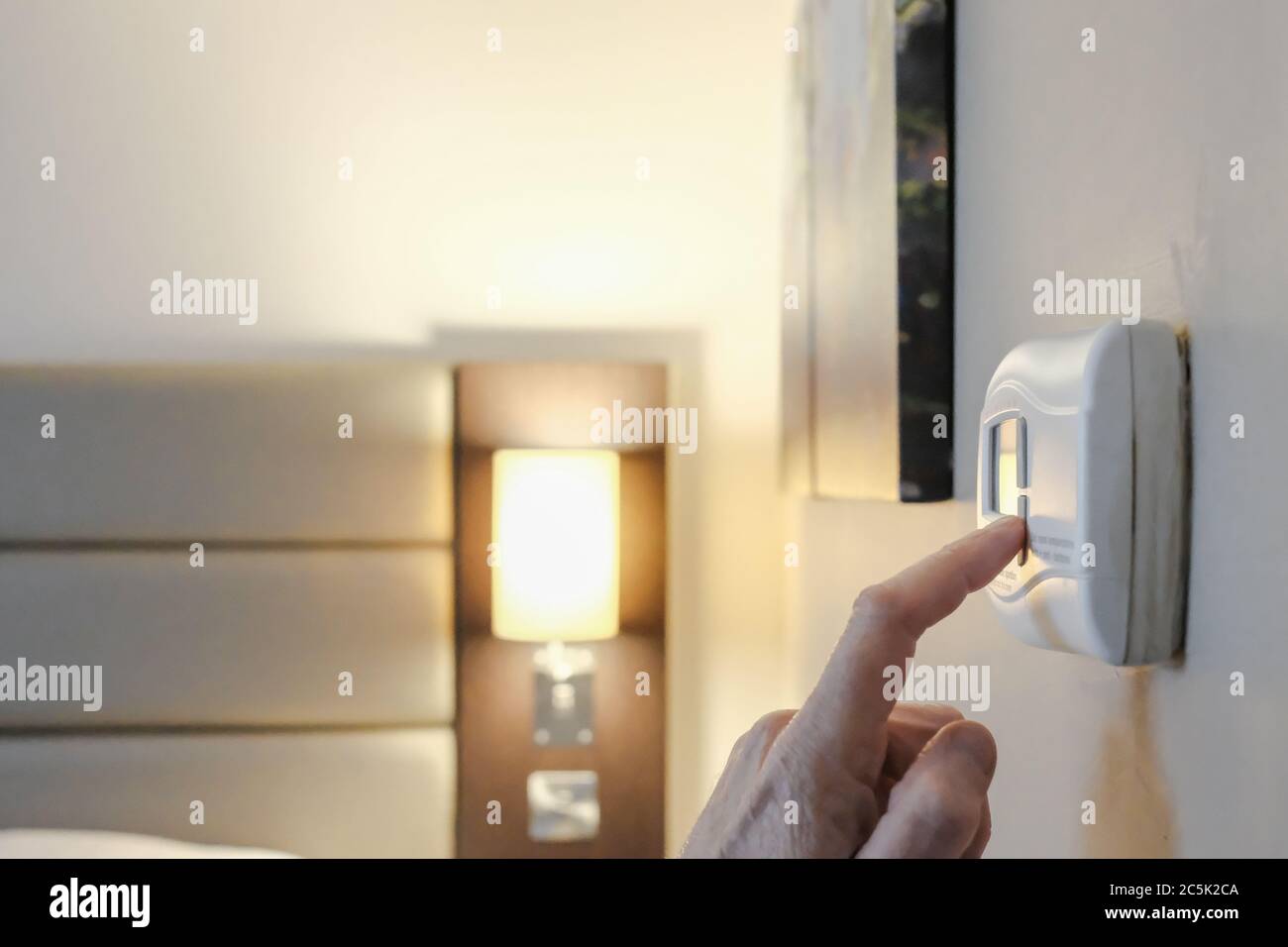 Hotel guest seen adjusting the air conditioning temperature on a