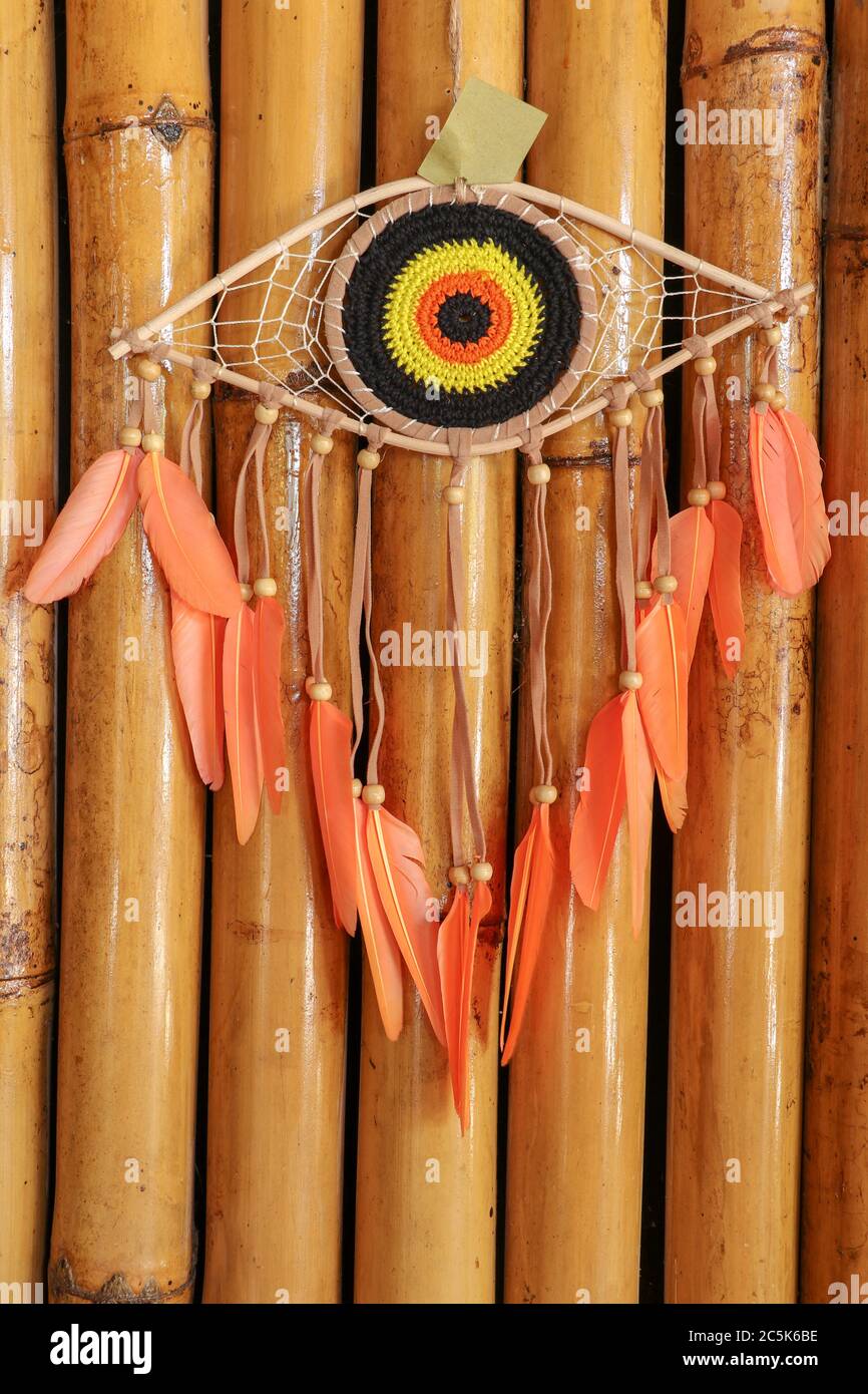 https://c8.alamy.com/comp/2C5K6BE/divine-eye-of-providence-dreamcatcher-with-colored-feathers-on-a-wodden-background-2C5K6BE.jpg