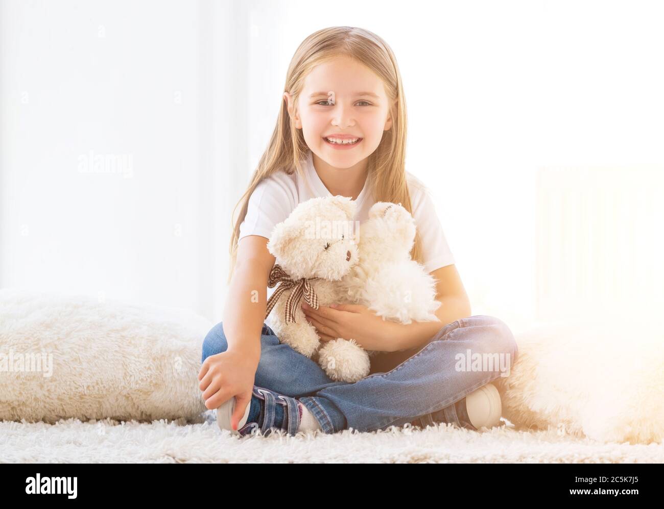 Joyful little girl hugging toys in playroom Stock Photo Alamy