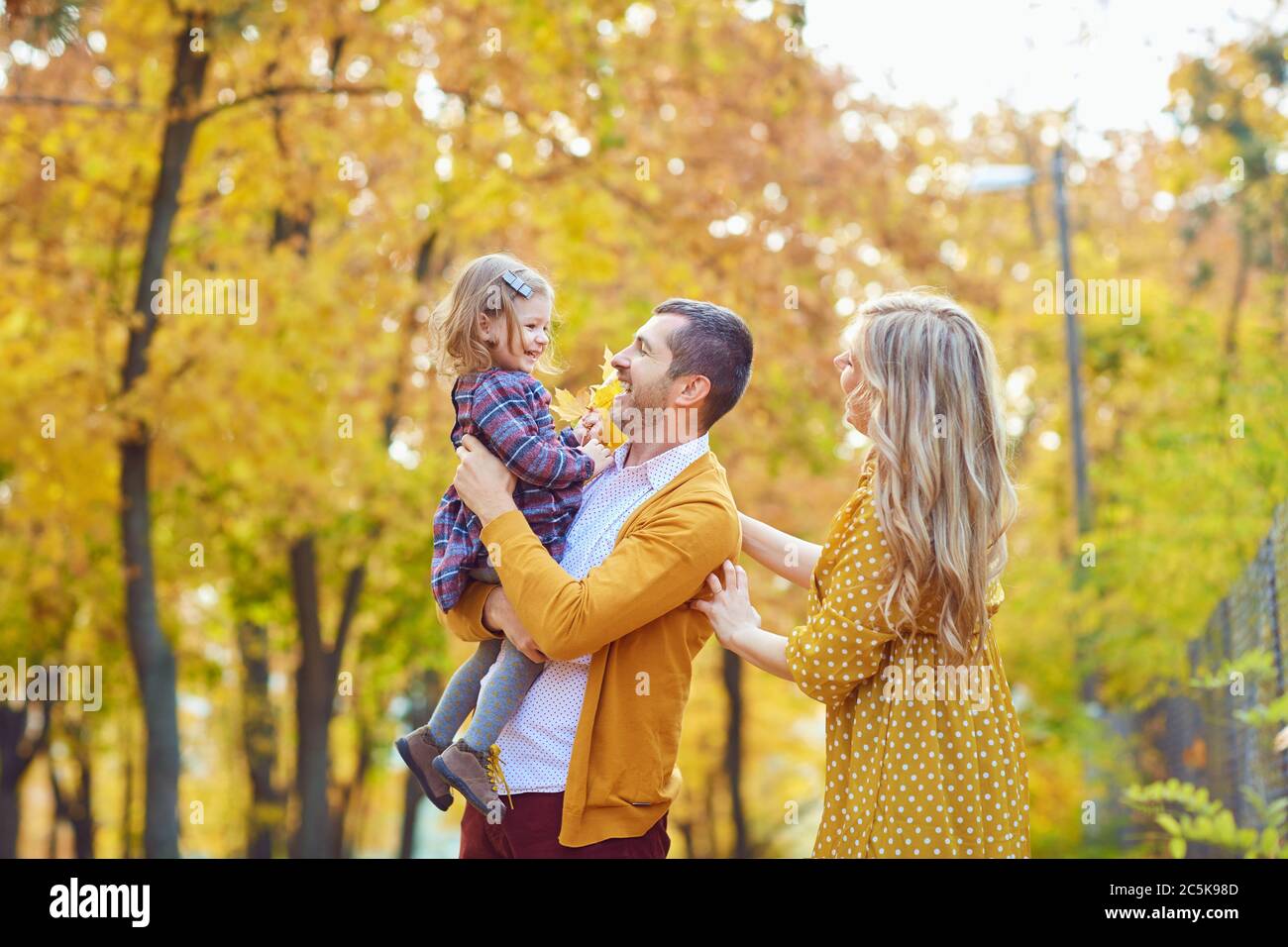 Family playing with baby in yellow park in autumn Stock Photo - Alamy