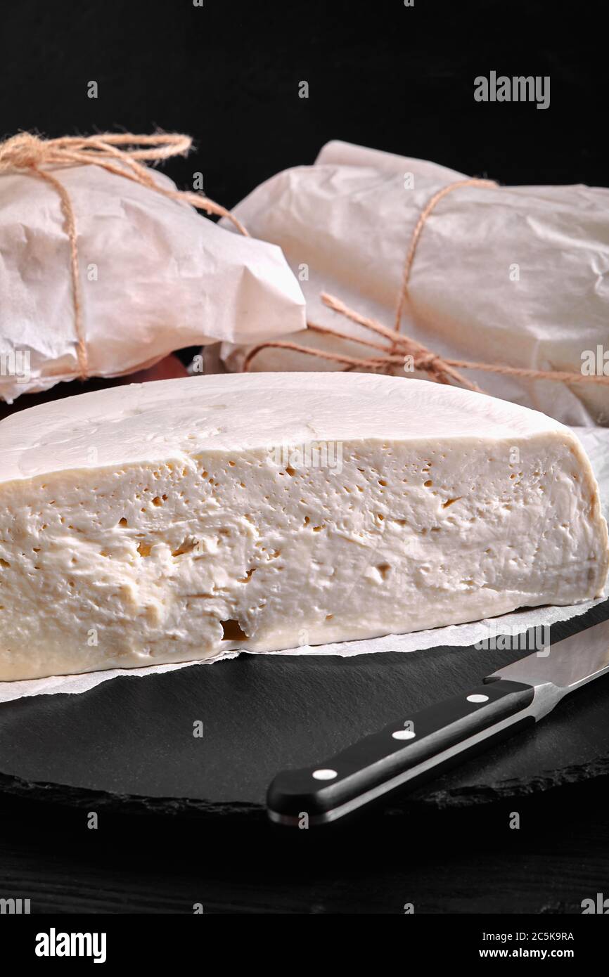 Traditional Caucasian homemade cheese sulguni on stone board, selective focus Stock Photo