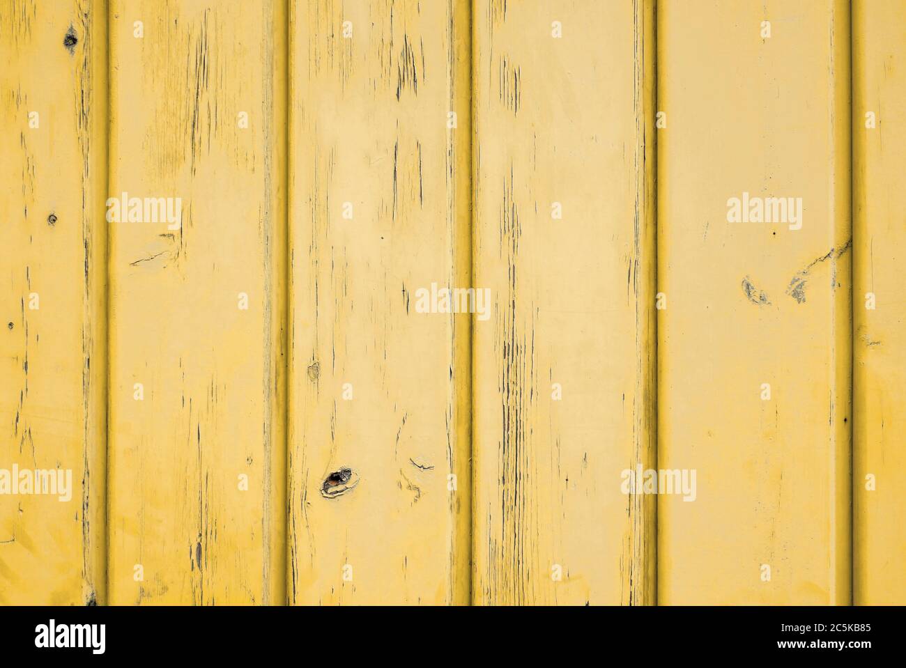 Background of sun yellow weathered wood with vertical planks. Stock Photo