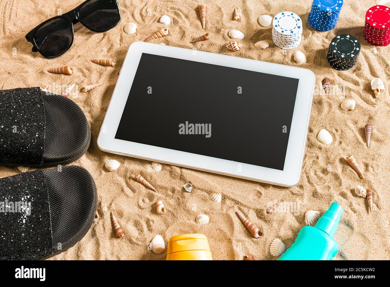 online-poker-game-on-the-beach-with-digital-tablet-and-stacks-of-chips-top-view-2C5KCW2.jpg