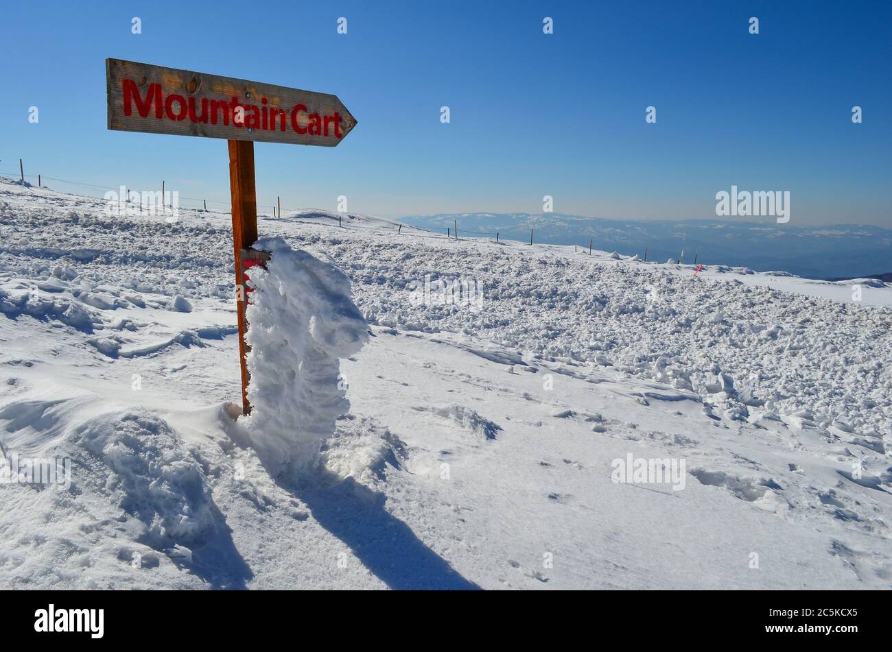Wooden signboard on snow, showing direction to Mountain Cart, ski resort Kopaonik, Serbia Stock Photo