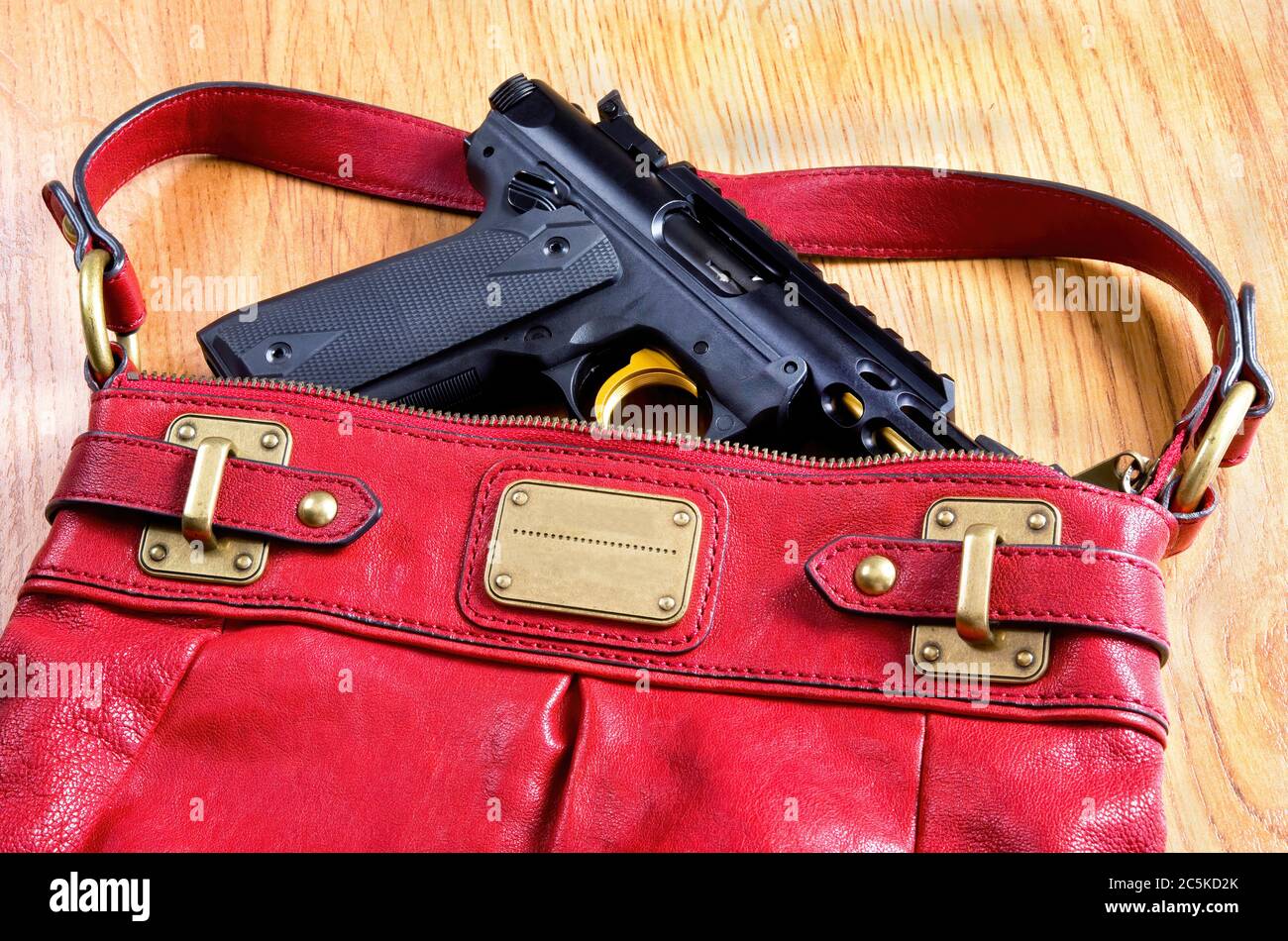 Ladies handbag packing pistol for self defense. Stock Photo
