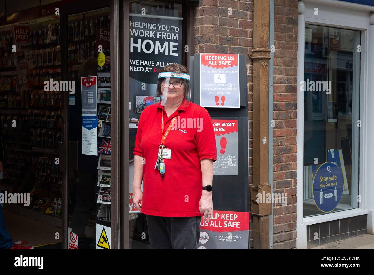 Windsor, Berkshire, UK. 3rd July, 2020. A member of staff at Ryman stationers shop in Windsor, Berkshire waits outside to advise customers on adhering to Coronavirus hygiene rules in their shop. Credit: Maureen McLean/Alamy Stock Photo