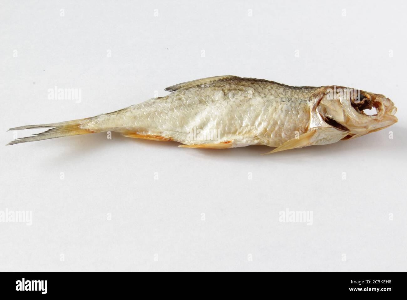 Dried fish on gray background. Salty dry river fish on a light gray background. Top view. Copy space. Stock Photo