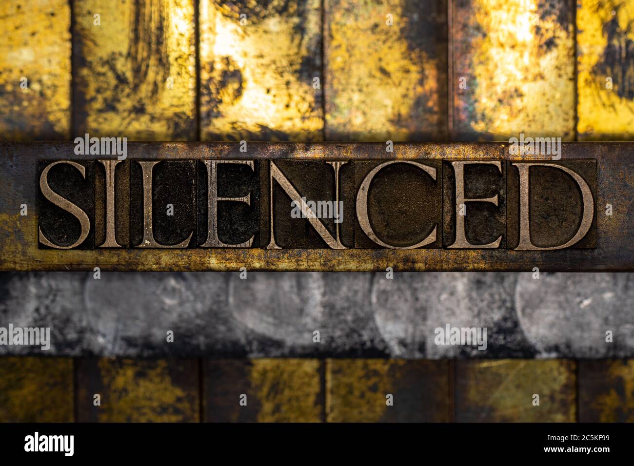 Silenced text formed with real authentic typeset letters on vintage textured silver grunge copper and gold background Stock Photo
