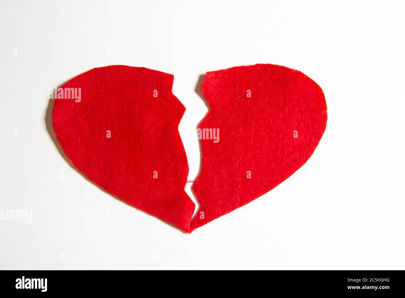 Broken red heart made of felt. Broken love concept. A broken heart isolated  on a white background. A pain in my heart Stock Photo - Alamy