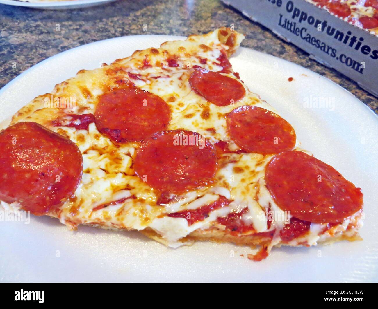One slice of pepperoni pizza on a white plate Stock Photo - Alamy