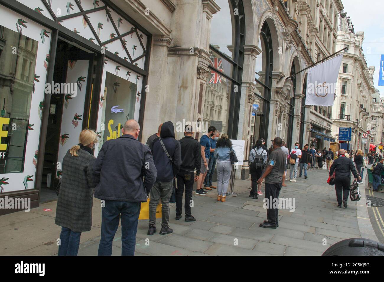 Westminster, London, UK - 3 July 2020: Customers queue at the Apple shop on Regent Street. All customers had to be temperature checked to be admitted. Daily life in London on a friday ahead of the opening of pubs on the 4th of July as per new Government advice. Stock Photo
