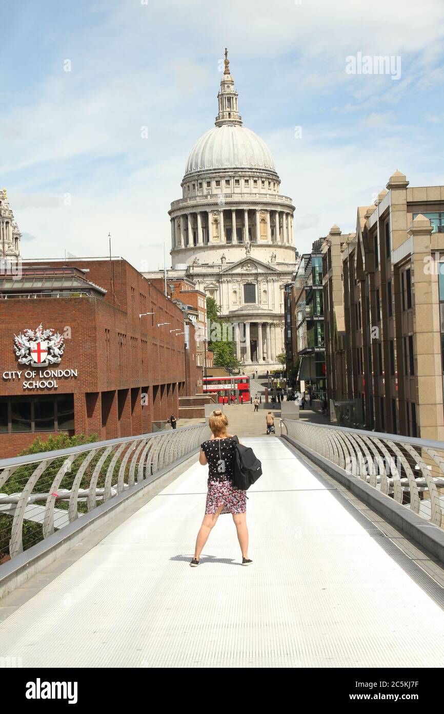 A tourist takes photos of St Paul's  from the Millenium Bridge. Daily life in London on a friday ahead of the opening of pubs on the 4th of July as per new Government advice. Stock Photo