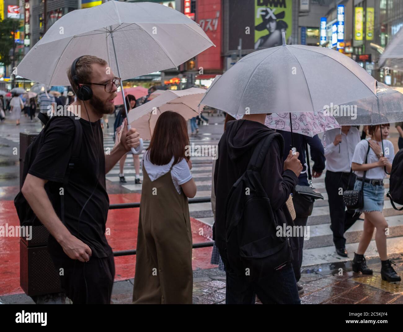 Male tourist with umbrella at Shibuya crossing, Tokyo, Japan during a ...