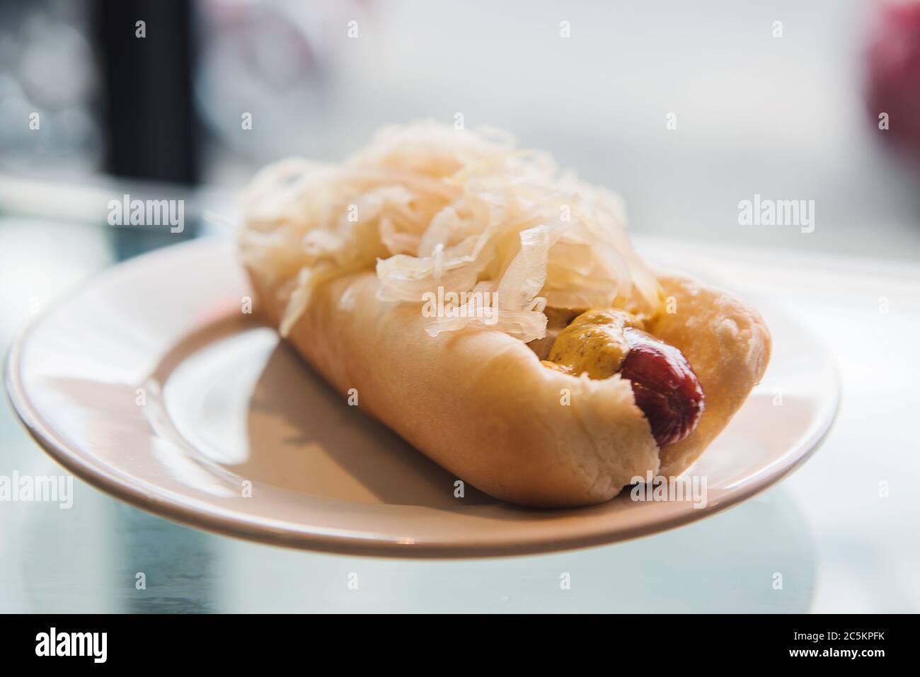 Hot dog with sauerkraut being served at a deli Stock Photo Alamy