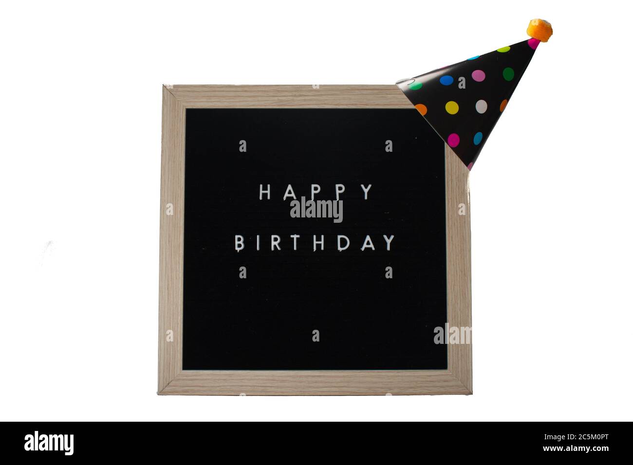 A Black Sign With a Birch Frame That Says Happy Birthday With a Black Polka-Dotted Birthday Hat and an Orange Cotton Ball on Top on a Pure White Backg Stock Photo