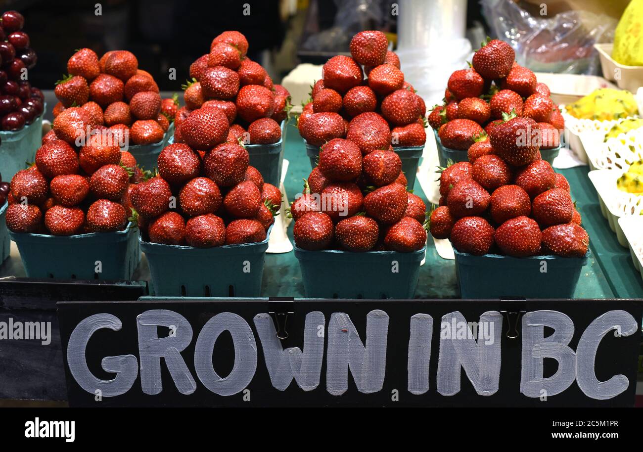 Locally grown strawberries are piled up in pyramids in the market on Granville Island in Vancouver, British Columbia, Canada. Stock Photo