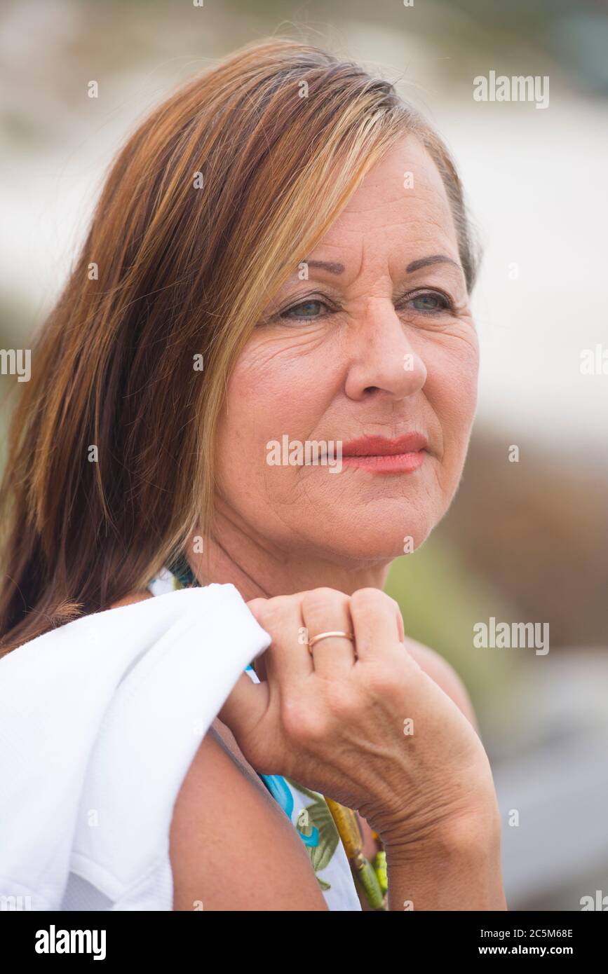 Portrait sad and thoughtful looking attractive mature woman outdoor with blurred background. Stock Photo