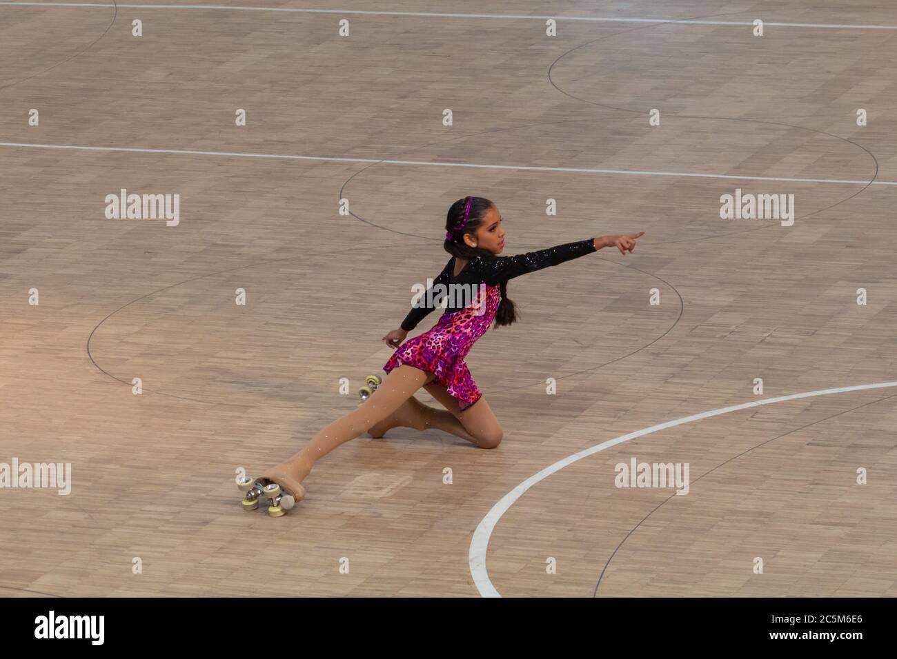 Little girl on roller skates of figure skating in a competition with