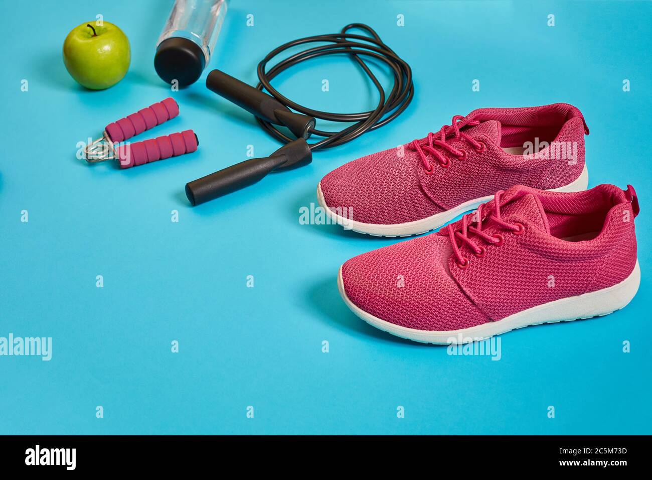 Flat lay of dumbbell, bottle of water, jump rope and sneaker, sport equipments, fitness items