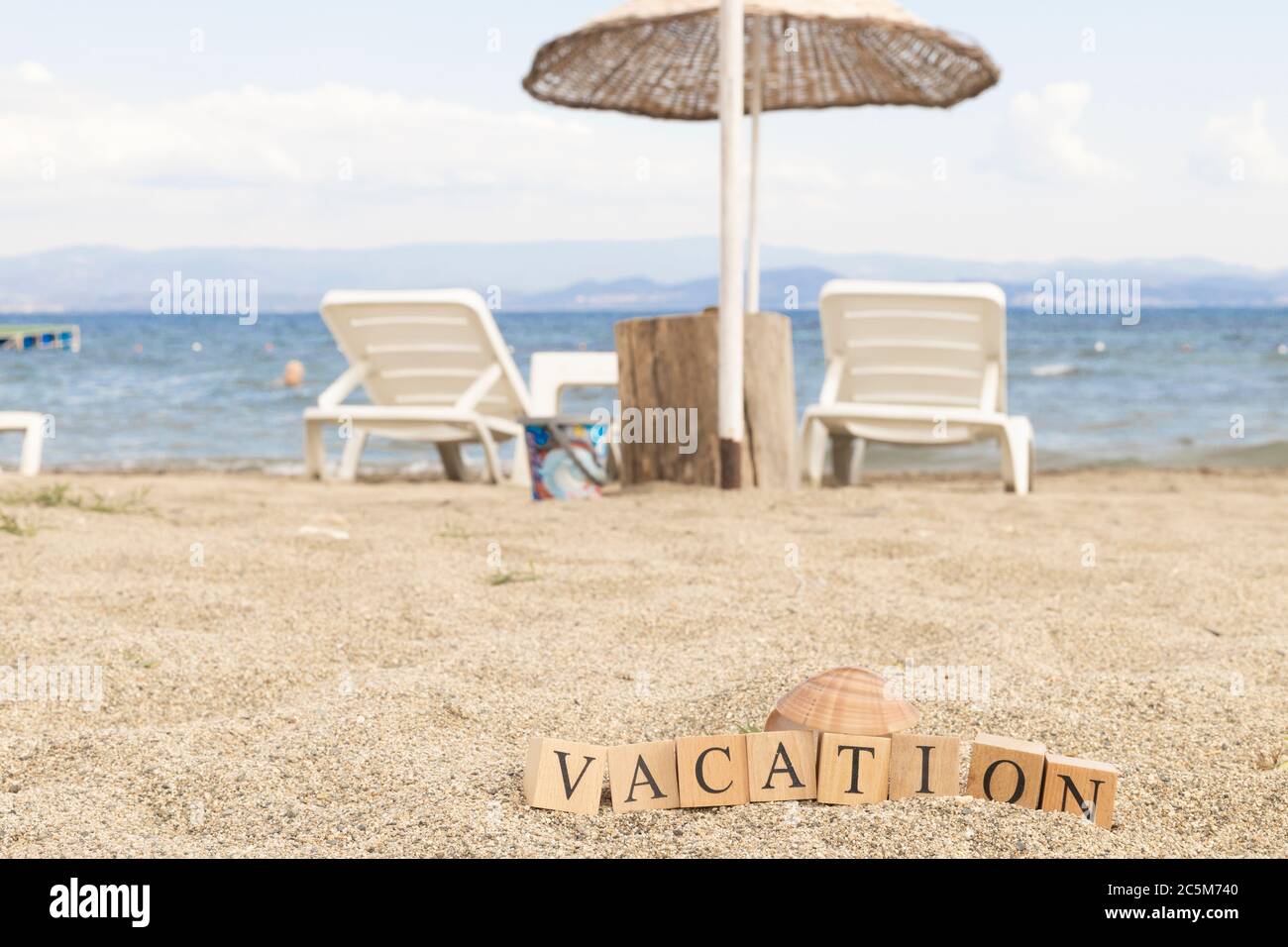 Holiday concept from wooden cubes. Wooden cubes embedded in sand Stock ...