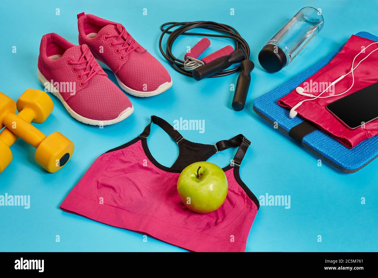 Flat lay of dumbbell, bottle of water, jump rope and sneaker, sport equipments, fitness items